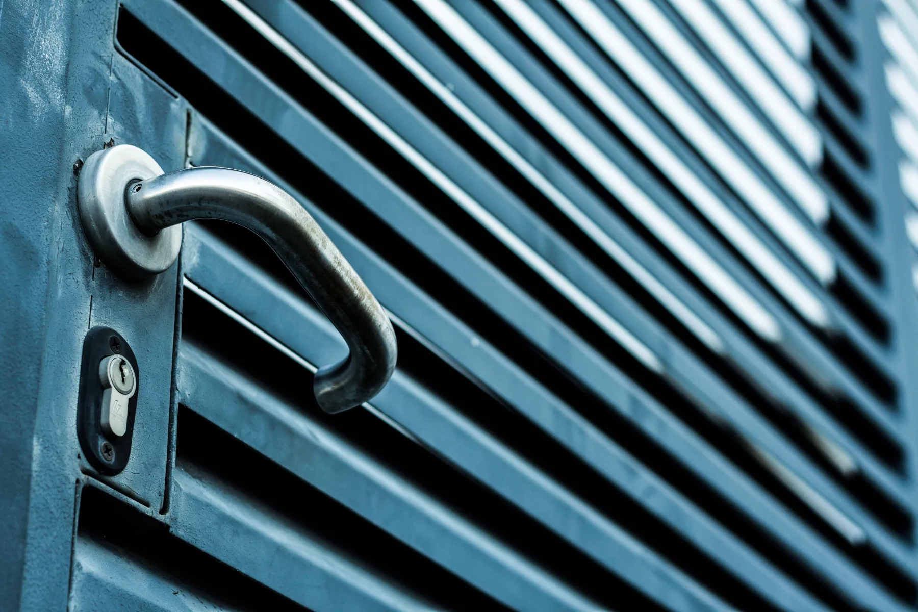 Modern brushed steel door handle and lock set on architectural entrance